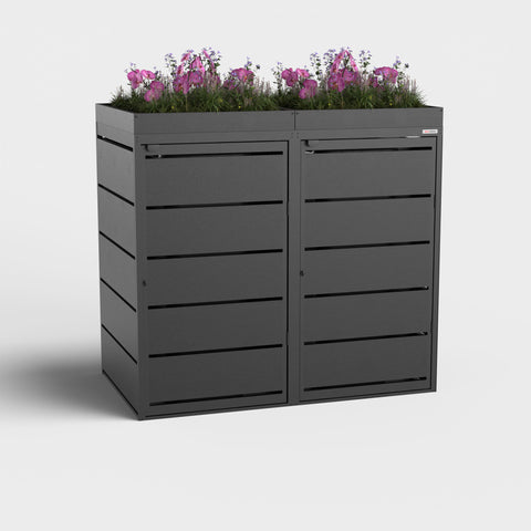 Schwarze Mülltonnenbox von BIO Stefan mit Pflanzdach und Blumen.