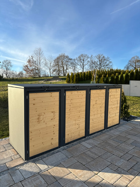 Holzmichl Mülltonnenbox aus Holz mit grauem Rahmen auf gepflastertem Boden im Freien.