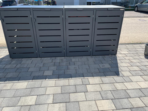 BIO Stefan Alubert Mülltonnenbox 4er in Anthrazit auf gepflasterter Einfahrt vor Parkplatz