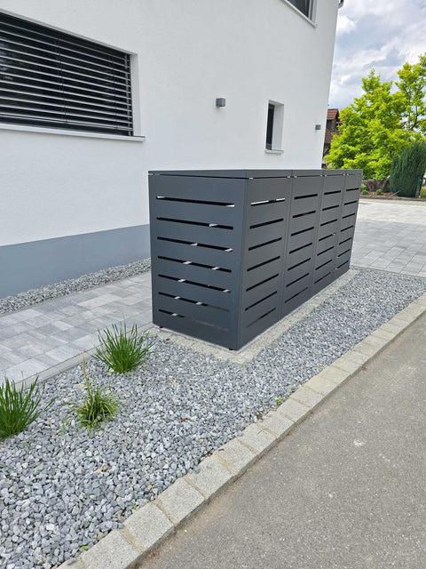 BIO Stefan Mülltonnenbox Alubert Anthrazit 4er 240l vor modernem weißen Haus auf Kiesfläche