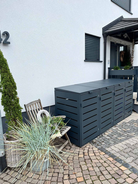 BIO Stefan Alubert Mülltonnenbox 4er 240l in Anthrazit vor Hausfassade mit Pflanzen und Gartenstuhl