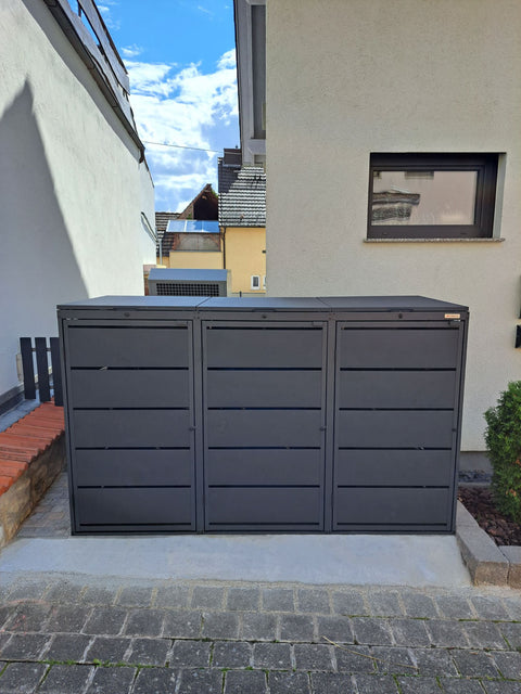 BIO Stefan Dagobert Mülltonnenbox 3er 240l in Anthrazit mit Deckel, Nahansicht der Lamellenfront mit drei Türen auf Betonfläche