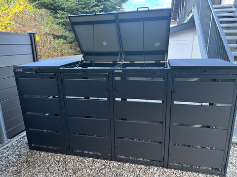 BIO Stefan Dagobert Mülltonnenbox 4er 120l in Anthrazit, zwei Deckel geöffnet, auf Kies vor Haus