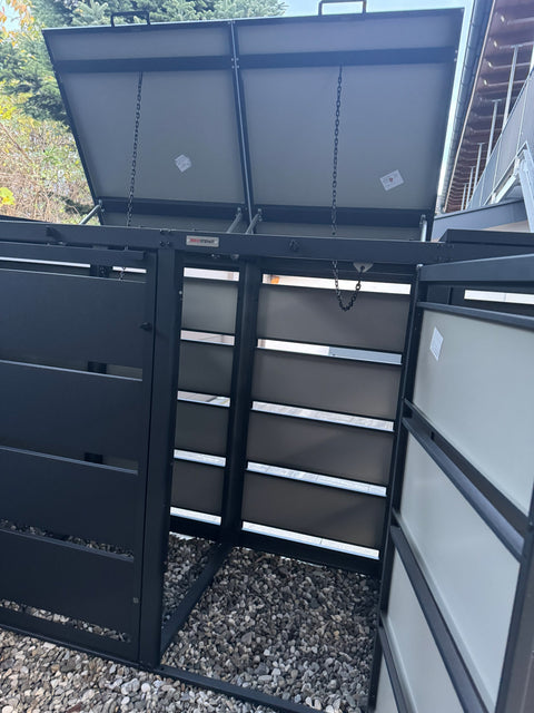 BIO Stefan Mülltonnenbox Dagobert 4er 120l in Anthrazit, geöffnete Deckel mit Ketten auf Kiesfläche