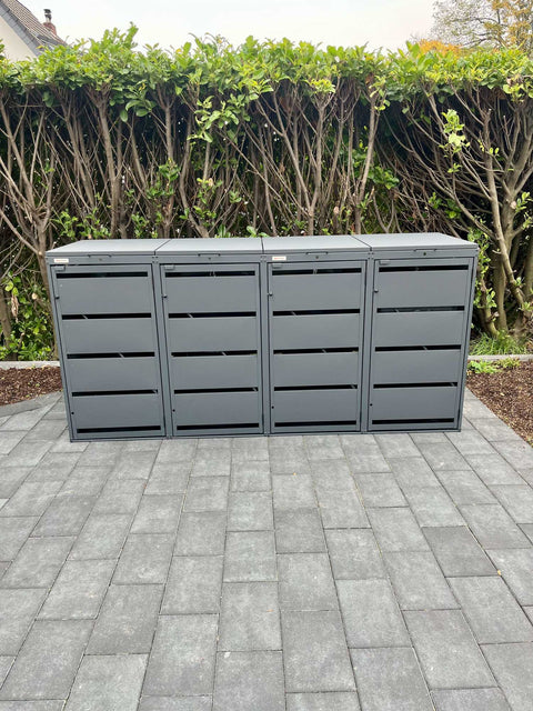 BIO Stefan Dagobert Mülltonnenbox 4er 120l in Anthrazit auf grauer Terrasse vor grüner Hecke