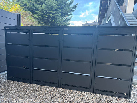 BIO Stefan Mülltonnenbox Dagobert 4er 120l in Anthrazit steht auf Kies vor Hausfassade