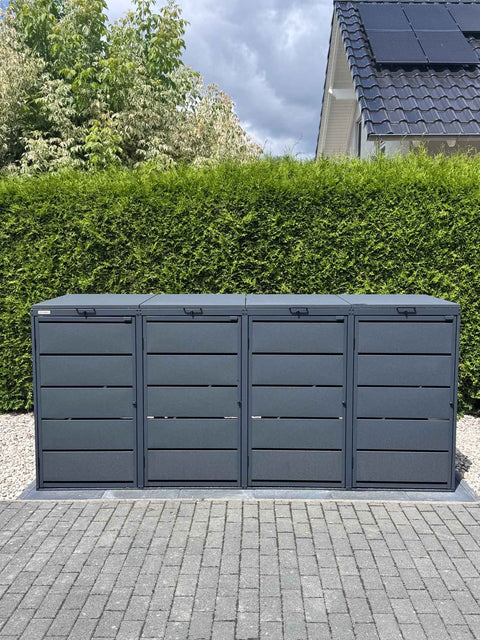 BIO Stefan Dagobert Mülltonnenbox 4er 240l in Anthrazit vor Hecke neben Haus mit Solardach
