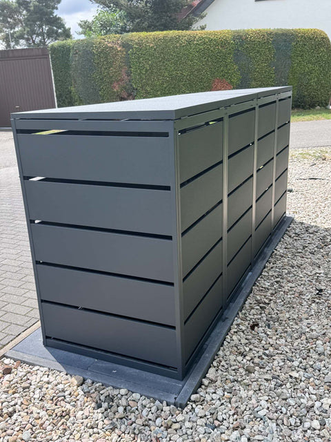 BIO Stefan Dagobert Mülltonnenbox 4er 240l in Anthrazit, freistehend auf Kies vor Hecke