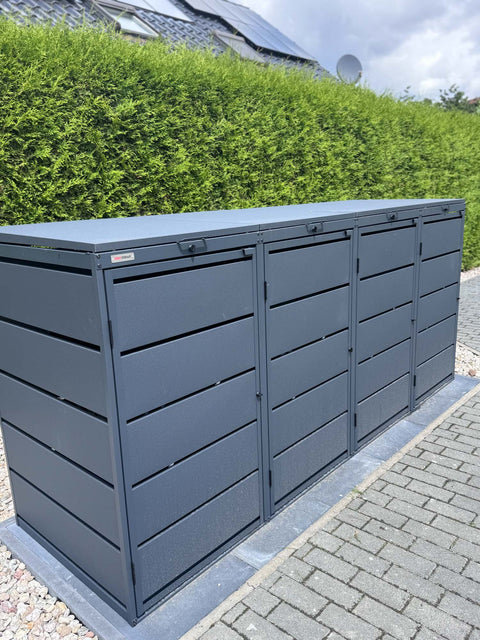 BIO Stefan Mülltonnenbox Dagobert 4er 240l in Anthrazit, freistehend vor grüner Hecke