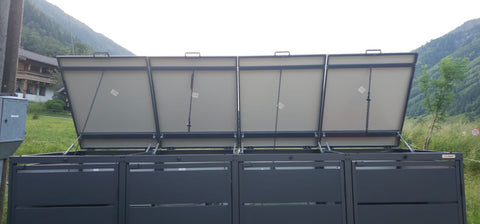 BIO Stefan Dagobert Mülltonnenbox 4er 240l in Anthrazit mit geöffneten Deckeln vor grüner Berglandschaft