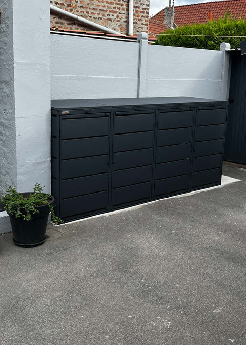 BIO Stefan Dagobert Mülltonnenbox 4er 240l in Anthrazit steht an Hauswand neben schwarzem Blumentopf