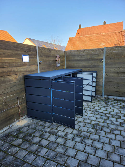 BIO Stefan Dagobert Mülltonnenbox 4er 240l in Anthrazit, teils geöffnete Türen auf gepflasterter Terrasse