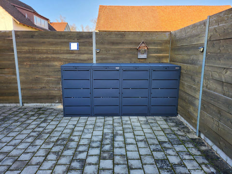 BIO Stefan Dagobert Mülltonnenbox 4er 240l in Anthrazit vor Holzzaun auf gepflasterter Terrasse