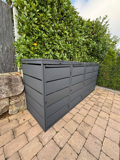 BIO Stefan Dagobert Mülltonnenbox 4er 240l in Anthrazit auf gepflasterter Terrasse vor grüner Hecke