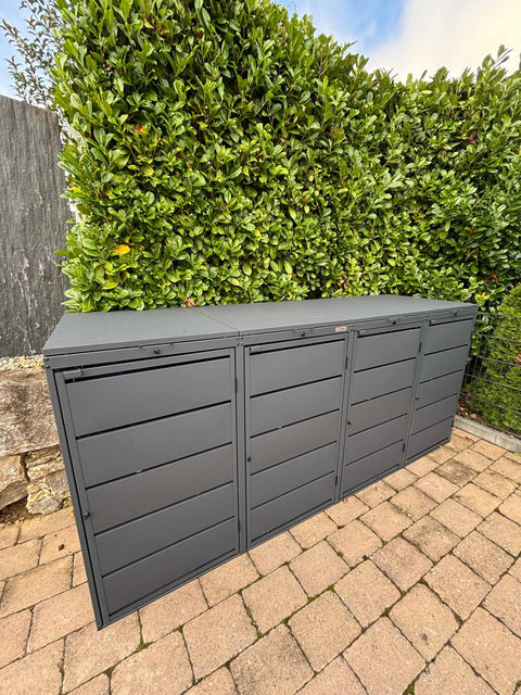 BIO Stefan Dagobert Mülltonnenbox 4er 240l in Anthrazit auf Terrasse vor grüner Hecke