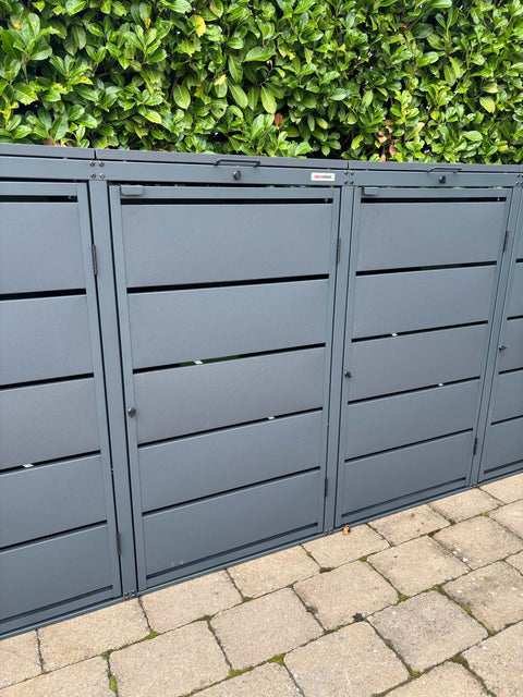 BIO Stefan Dagobert Mülltonnenbox 4er 240l in Anthrazit vor grüner Hecke auf Pflastersteinen