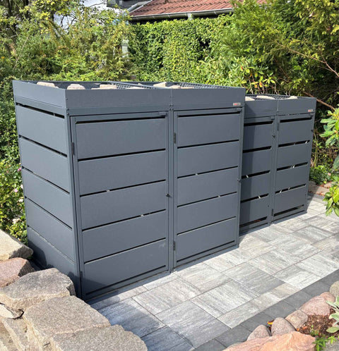 BIO Stefan Dagobert Mülltonnenbox 4er Kombination 120l und 240l in Anthrazit mit Pflanzdach, Frontansicht der vier Boxen mit Querlamellen auf gepflasterter Terrasse