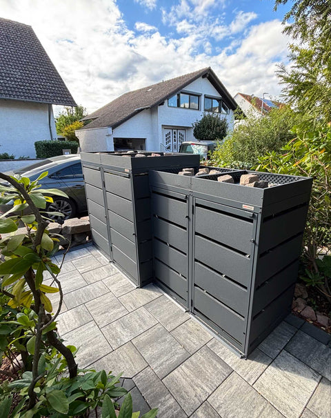 BIO Stefan Dagobert Mülltonnenbox 4er Kombination 120l und 240l in Anthrazit mit Pflanzdach, über Eck aufgestellt neben Rhododendron im Einfahrtsbereich