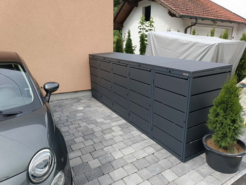 BIO Stefan Dagobert Mülltonnenbox 5er 240l in Anthrazit neben parkendem Auto entlang der Einfahrt