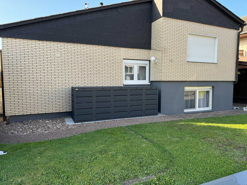 BIO Stefan Dagobert Mülltonnenbox 5er 240l in Anthrazit an der Backsteinfassade neben dem Rasen
