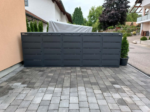 BIO Stefan Dagobert Mülltonnenbox 5er 240l in Anthrazit freistehend an der Hausfassade auf gepflastertem Hof