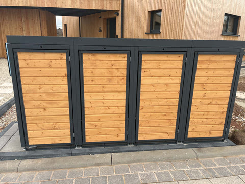 BIO Stefan Mülltonnenbox Holzmichl Anthrazit, 4er 120l mit Holzfront und Pflanzdach vor Holzhaus