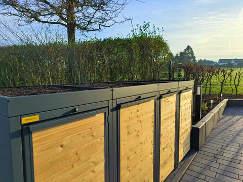 BIO Stefan Mülltonnenbox Holzmichl anthrazit, 4er 120l mit Holzfront und Pflanzdach entlang gepflastertem Weg