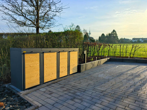 BIO Stefan Holzmichl Mülltonnenbox 4er 120l in Anthrazit mit Holzfront und Pflanzdach auf gepflasterter Einfahrt