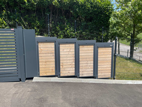 BIO Stefan Holzmichl Mülltonnenbox 4er 120l in Anthrazit mit Holzfront und Pflanzdach vor Zaun