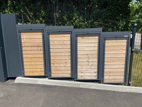 BIO Stefan Holzmichl Mülltonnenbox 4er 120l in Anthrazit mit Holzfront, Pflanzdach-Gefälle vor Zaun