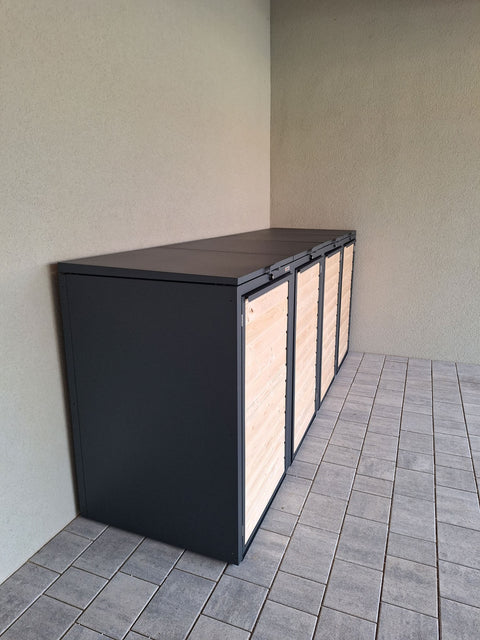 BIO Stefan Mülltonnenbox Holzmichl Anthrazit, Holzfront 4er 240l an Hauswand auf Pflasterfläche