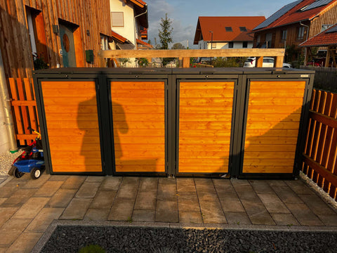 BIO Stefan Mülltonnenbox Holzmichl Anthrazit Holzfront 4er 240l vor Einfamilienhaus im Abendlicht