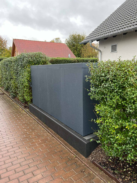 BIO Stefan Mülltonnenbox Holzmichl Anthrazit 4er 240l mit Pflanzdach steht entlang Hecke vor Einfamilienhaus