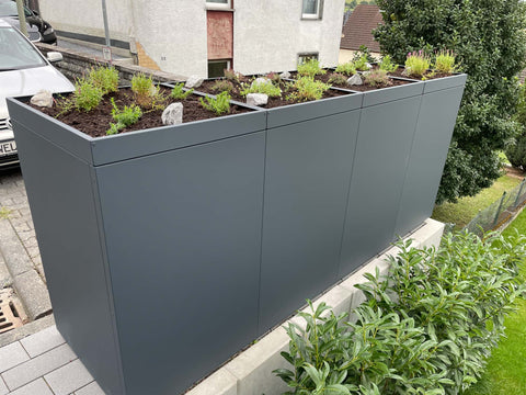 BIO Stefan Mülltonnenbox Holzmichl Anthrazit 4er 240l mit Pflanzdach, seitlich im Garten aufgenommen