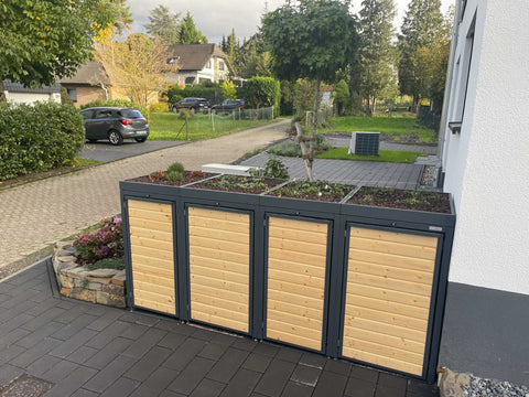 BIO Stefan Holzmichl Mülltonnenbox 4er Kombination 120l 240l in Anthrazit mit Holzfront und bepflanztem Pflanzdach vor Haus
