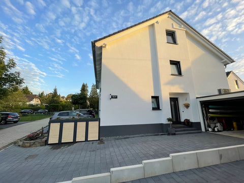 BIO Stefan Holzmichl Mülltonnenbox 4er Kombination 120l 240l in Anthrazit mit Holzfront und Pflanzdach vor Einfamilienhaus