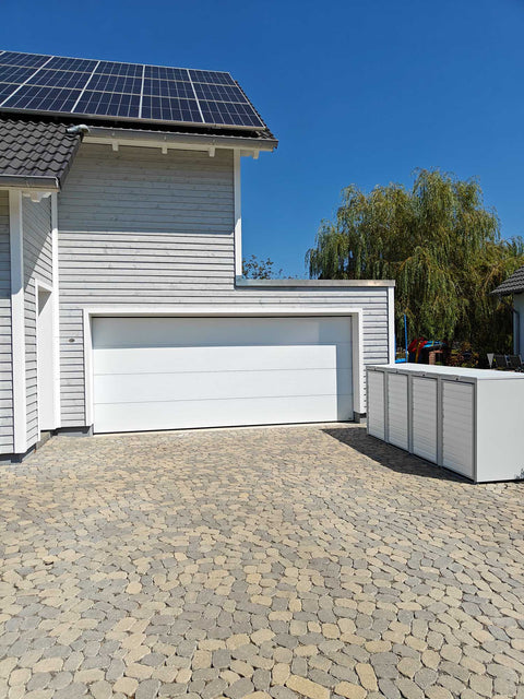 BIO Stefan Mülltonnenbox Holzmichl Reinweiß RAL9010, 4er 240l mit Holzfront neben moderner Garage