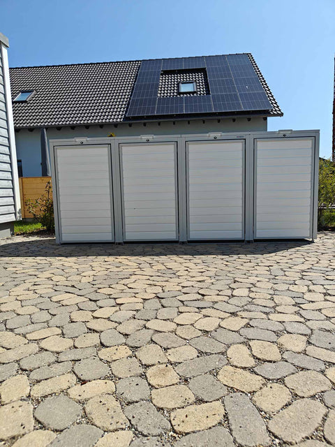 BIO Stefan Holzmichl Mülltonnenbox 4er 240l in Reinweiß RAL9010 vor Haus mit Solardach