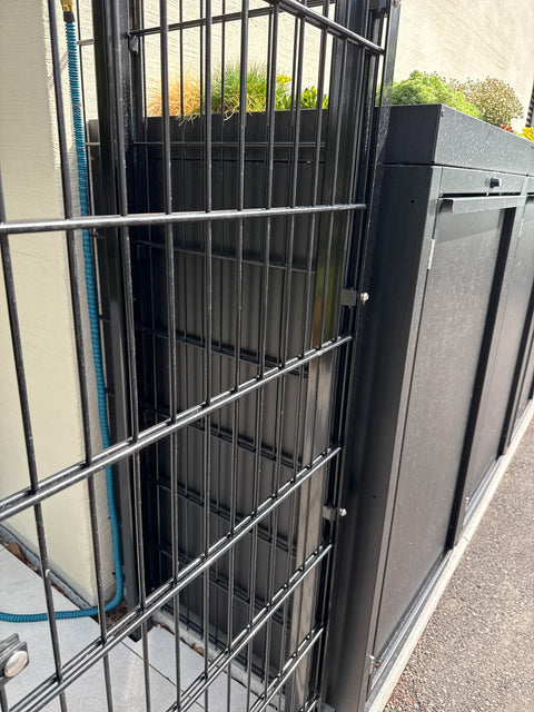BIO Stefan Stahlfred Mülltonnenbox 3er 240l in Schwarz RAL 9005 mit Pflanzdach bündig hinter schwarzem Doppelstabmattenzaun