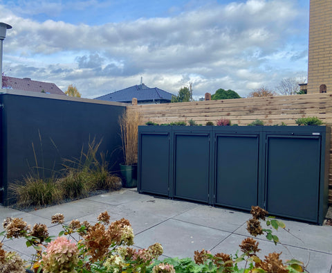 Box pour poubelles de BIO Stefan avec toit végétal dans un jardin moderne.