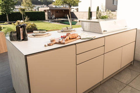 Outdoor kitchen as a cooking island with a bar counter: grill at the front, sit at the back