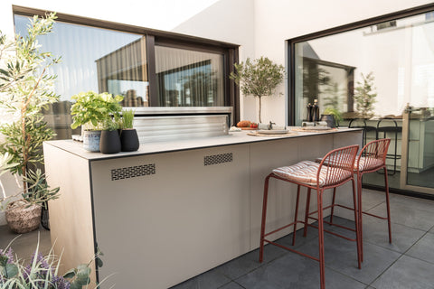 Outdoor kitchen as a cooking island with a bar counter: grill at the front, sit at the back