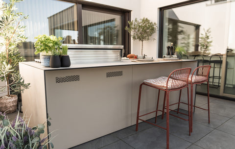 Outdoor kitchen as a cooking island with a bar counter: grill at the front, sit at the back