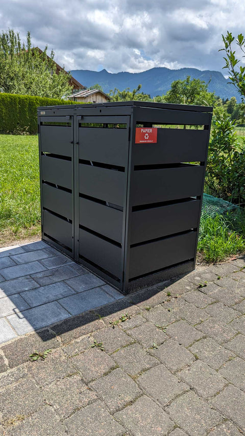BIO Stefan Dagobert Muelltonnenbox 2er 120l in Anthrazit freistehend im Garten auf Plattenfundament mit Blick auf die Berge