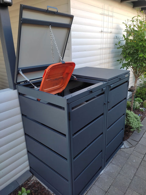 BIO Stefan Dagobert Muelltonnenbox 2er 120l in Anthrazit mit geoeffnetem Klappdeckel und Verbindungskette die den orangen Tonnendeckel mithebt