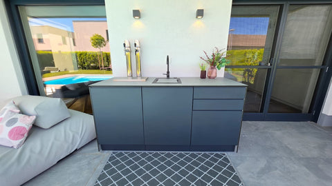 Outdoor bar by the pool: anthracite sink unit with beer tap and concrete look