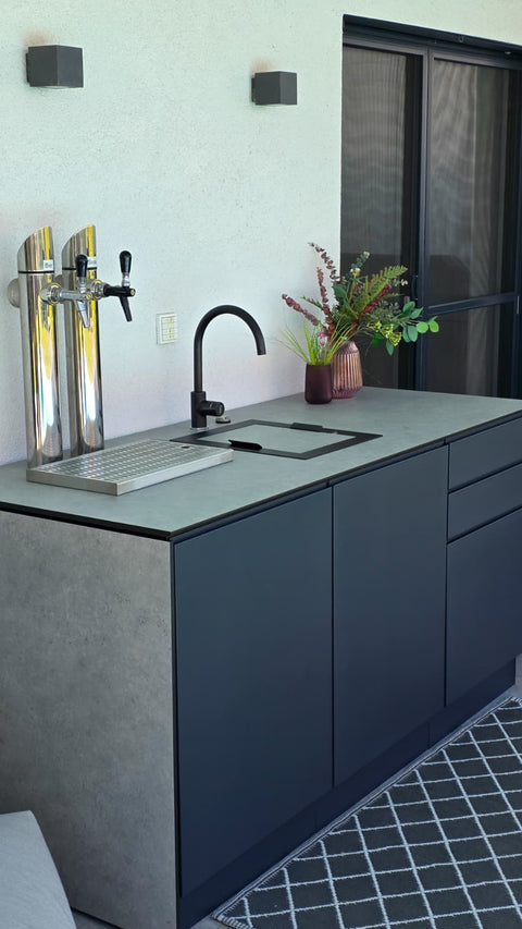 Outdoor bar by the pool: anthracite sink unit with beer tap and concrete look