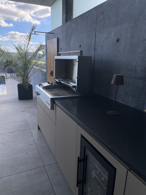 Outdoor kitchen by the pool with Flammkraft grill: front in gray-beige beneath the concrete roof