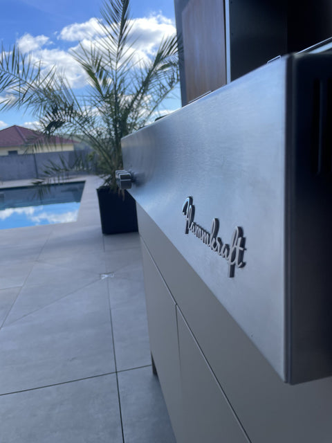 Outdoor kitchen by the pool with Flammkraft grill: front in gray-beige beneath the concrete roof