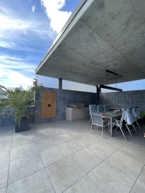 Outdoor kitchen by the pool with Flammkraft grill: front in gray-beige beneath the concrete roof